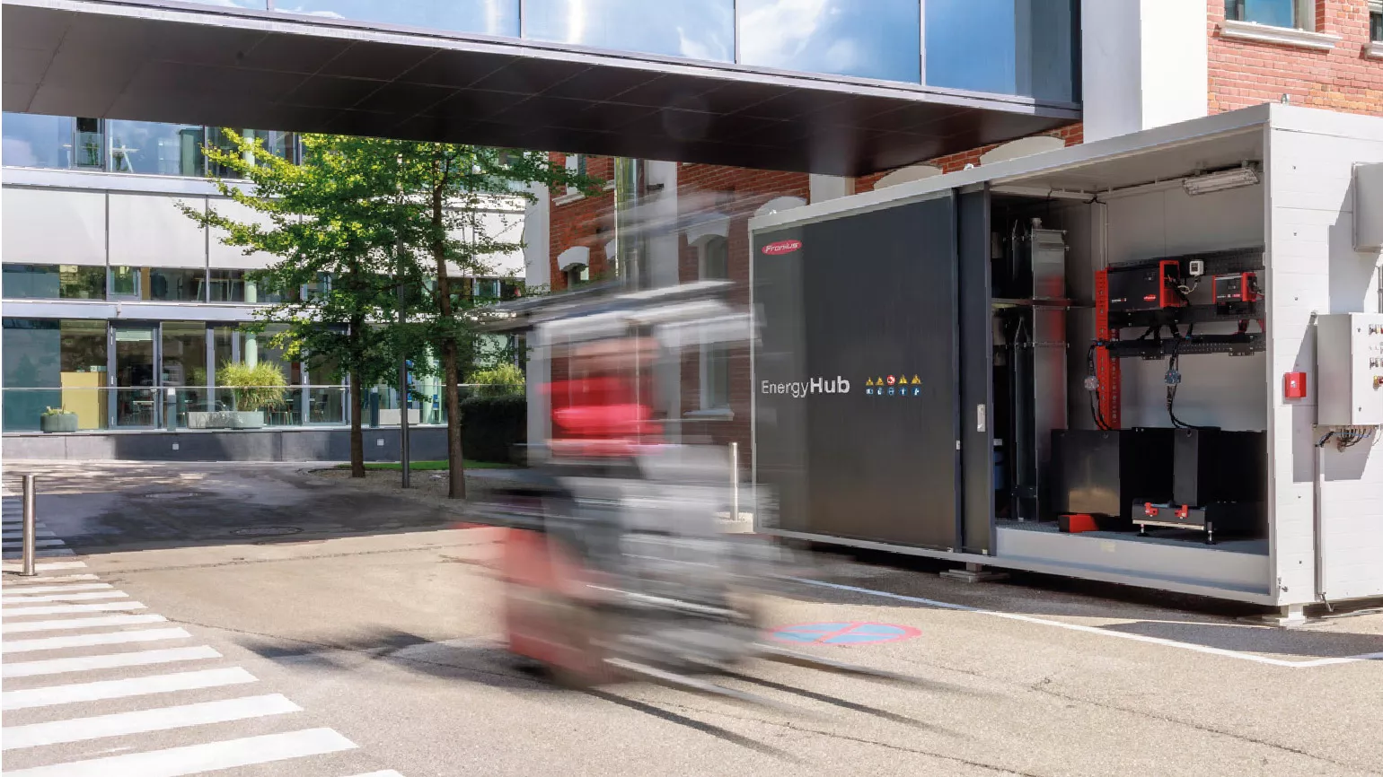 Fronius EnergyHub und EnergyCase vor einem Backsteingebäude.
