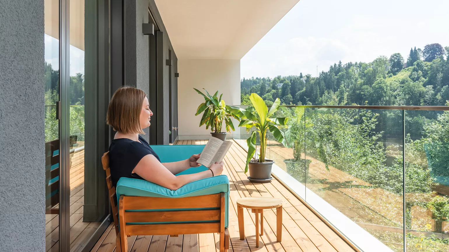 woman reading a book at the balcony